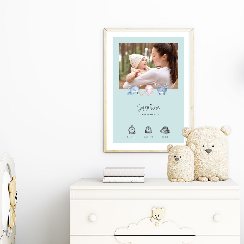 viser rektangulaer fødselstavle med soede illustrationer fra havets univers og 1 foto samt foedselsdata. Blå baggrund med hvid kant. Designet af www.plakatcompagniet.dk x