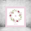 viser kvadratisk navneplakat med rosa blomsterkrans og rosa kant med tekst fra www.plakatcompagniet.dk