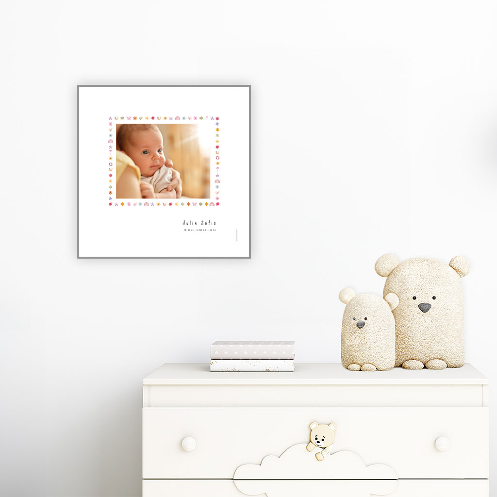 viser kvadratisk-foedselstavle med et foto-fornavn-foedselsdata-paa-hvid-baggrund-med kant-af-fine-smaa-illustrationer-designet af www.plakatcompagniet.dk. plakaten haenger over en hvid kommode paa et boernevaerelse