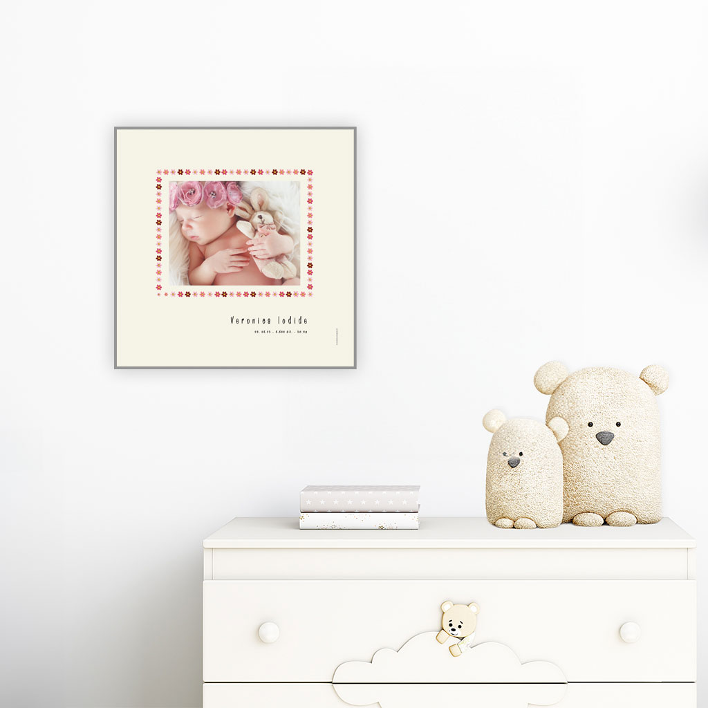 viser kvadratisk fødselstavle med et foto omkranset af en kant af lyseroede blomster illustrationer. Dertil fornavn og foedselsdata paa beige baggrund med hvid kant. Designet af www.plakatcompagniet.dk x