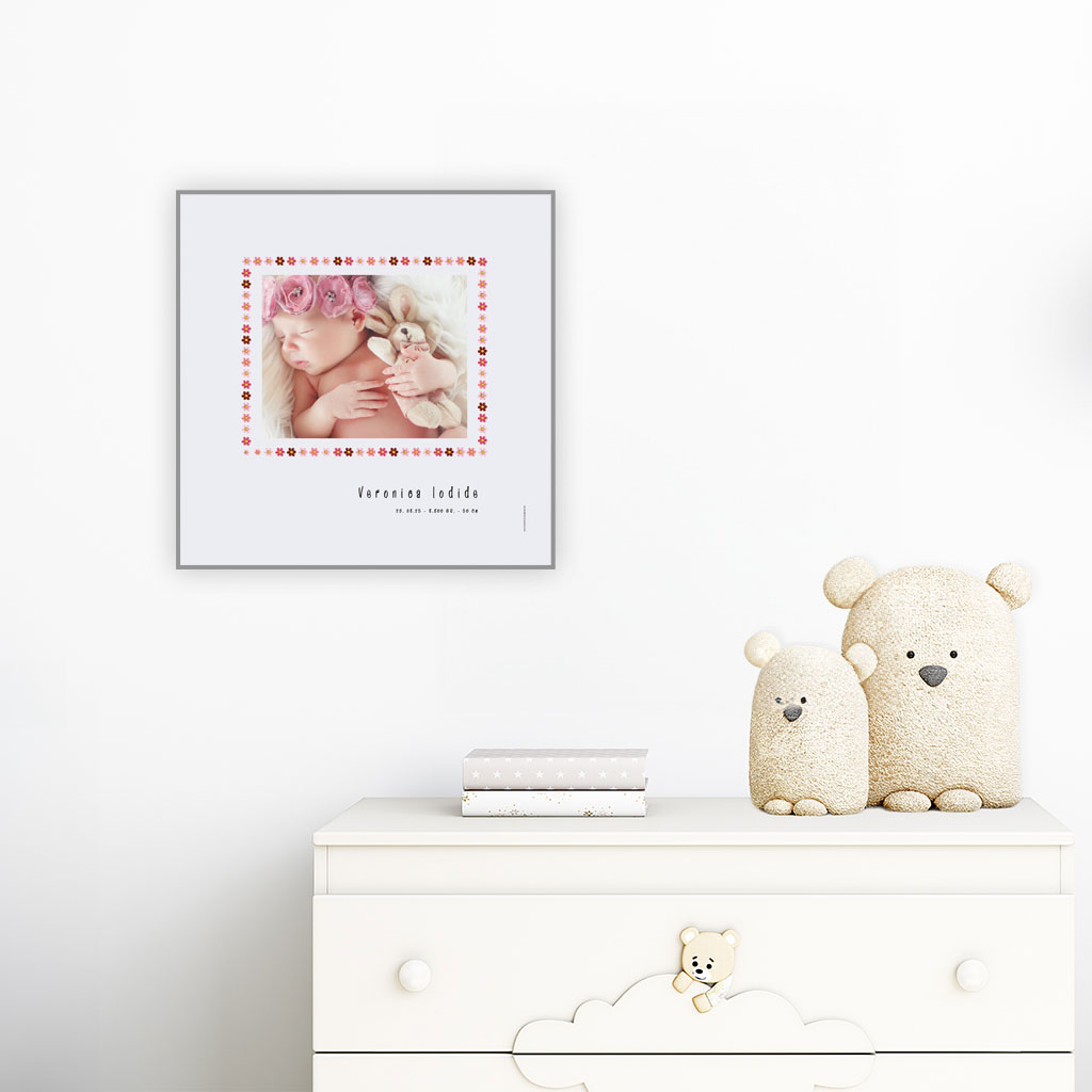 viser kvadratisk fødselstavle med et foto omkranset af en kant af lyseroede blomster illustrationer. Dertil fornavn og foedselsdata paa graa baggrund med hvid kant. Designet af www.plakatcompagniet.dk x