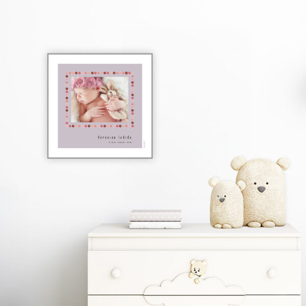 viser kvadratisk fødselstavle med et foto omkranset af en kant af lyseroede blomster illustrationer. Dertil fornavn og foedselsdata paa lilla baggrund og med hvid kant.. Designet af www.plakatcompagniet.dk. plakat haenger paa boernevaerelse over hvid kommode