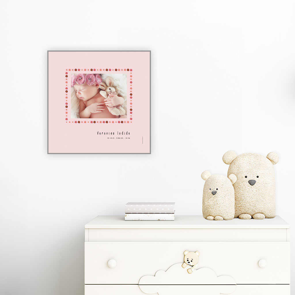 viser kvadratisk fødselstavle med et foto omkranset af en kant af lyseroede blomster illustrationer. Dertil fornavn og foedselsdata paa lyseroed baggrund med hvid kant. Designet af www.plakatcompagniet.dk x