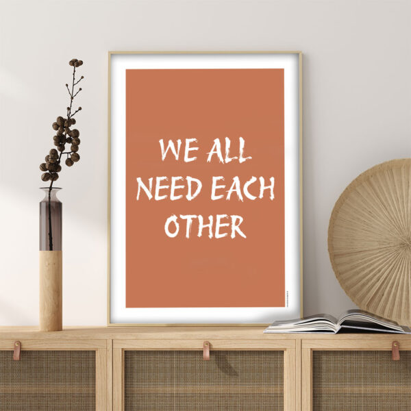 viser citatplakaten med citatet "We all need each other" på orange baggrund fra www.plakatcompagniet.dk