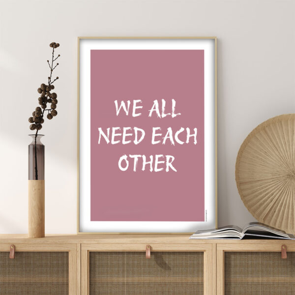 viser citatplakaten med citatet "We all need each other" på rosa baggrund fra www.plakatcompagniet.dk
