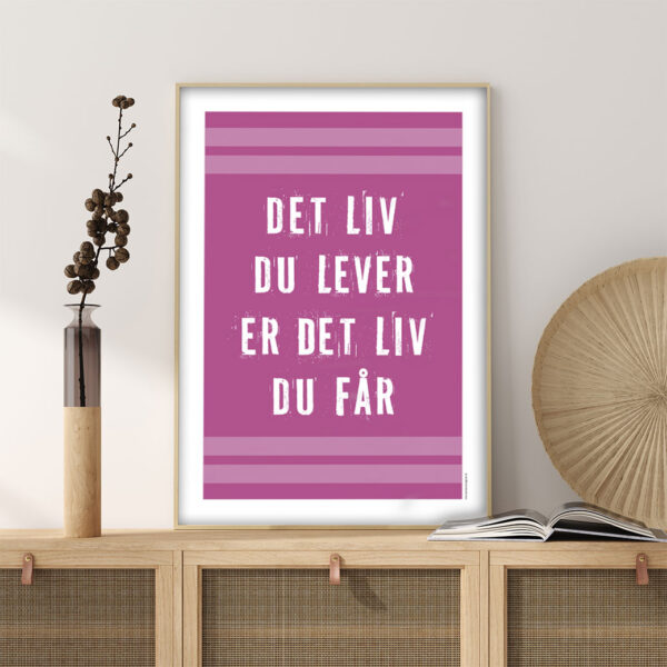 viser citatplakaten med citatet "Det liv du lever er det liv du får" på pink baggrund fra www.plakatcompagniet.dk