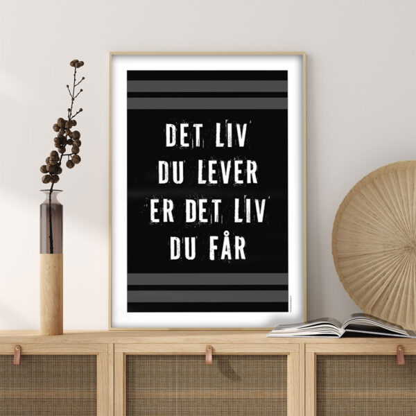 viser citatplakaten med citatet "Det liv du lever er det liv du får" på sort baggrund fra www.plakatcompagniet.dk