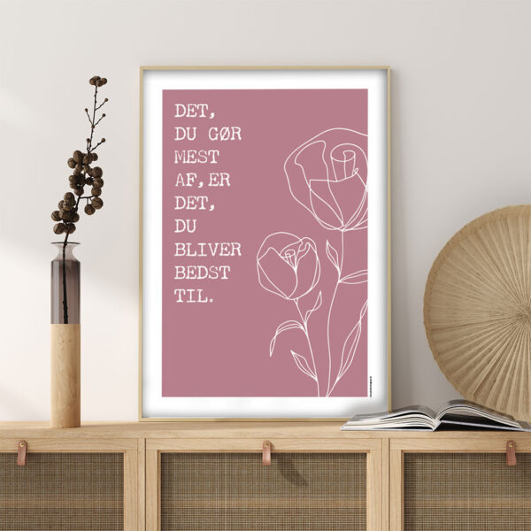 viser citatplakaten med citatet "Det du goer mest af er det du bliver bedst til" på rosa baggrund fra www.plakatcompagniet.dk